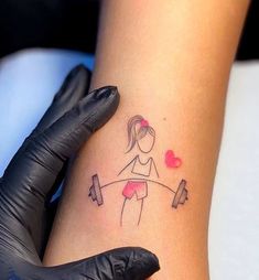 a woman's arm with a tattoo that has a girl holding a barbell on it