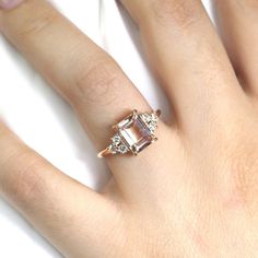 a woman's hand with a ring on it and an engagement ring in the middle