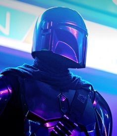 a man in a star wars costume standing next to a neon sign and wearing a helmet