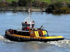 a yellow and black tug boat in the water