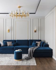 a living room with blue couches and gold chandelier