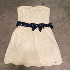 Nwt Hollister L White Strapless Dress. Comes With A Cute Bow Belt That’s Navy Blue With White Polka Dots. Super Cute! Waist Measures 14 Inches And Length Is 25. The Back Of The Dress Is Stretchy As Seen In Photos. From My Closet. Bought It But Never Had A Reason Or Place To Wear It And Now It No Longer Fits. Reasonable Offers Welcomed. Summer White Strapless Mini Dress, White Strapless Summer Mini Dress, White Cotton Strapless Sleeveless Dress, White Strapless Dress For Day Out, Casual White Mini Strapless Dress, Casual White Strapless Dress For The Beach, Casual White Strapless Dress For Spring, Casual White Strapless Dress For Beach, Casual White Strapless Dress