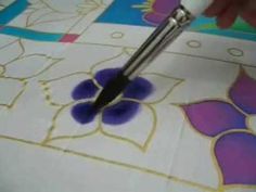 a person using a pair of scissors to paint flowers on a piece of art paper