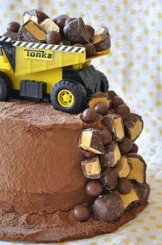 there is a cake that has a construction truck on it and chocolate candies all over the top