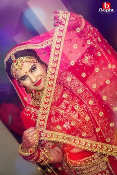 a woman in a red and gold bridal outfit