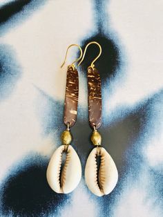 Blessings from divine messengers. These are made from coconut, brass and vintage cowrie shells from Burkina Faso. The are on gold fill hooks. Both the coconut and the cowrie shell are used in divination to communicate messages from Spirit. May these assist you in receiving what is for you.  Cowrie shells have been used around the world for adornment, currency and divination. They symbolize creation, abundance, protection, ancestors. They are considered the mouth of the gods, tools for communicat Cowrie Shell Jewelry Necklaces, Afro Jewelry, Cowrie Shell Jewelry, Wire Jewelry Earrings, African Earrings, Cowrie Shells, Seashell Jewelry, Dope Jewelry, Coconut Shell