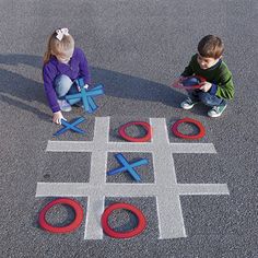 two children sitting on the ground playing with toy tic - tacquets