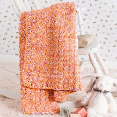 a crocheted blanket sitting on top of a white rocking chair