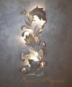 an artisticly designed wall light in the shape of a flower with leaves on it