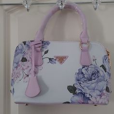 Finon Milano Floral Purple & White Hand Bag Nwot Still Has Original Plastic Wrapped Around The Handles Zips Across To Open And Close Gold Hardware Handle Drop Is Approx 6" Looks Like A Pencil/Pen Mark On Bottom. Smoke-Free Dog-Friendly Home Bundle 3 Items And Save 20% And One Shipping Fee First Purchase On Poshmark Use Code Katybugg78 For $10 Off. *Please Note That Color May Vary From Pictures Due To Lighting White Floral Print Satchel Shoulder Bag, White Floral Print Shopping Bag, White Floral Print Satchel Bag, White Floral Print Tote Bag, White Floral Print Shoulder Bag For Shopping, White Floral Print Tote Shoulder Bag, White Hand Bag, Coach Vintage Handbags, Concert Bags