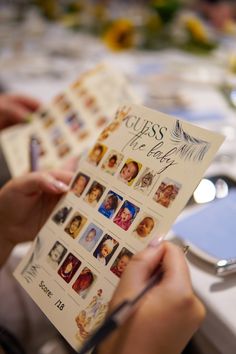 a person holding up a card with pictures on it at a table full of people