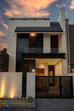 a modern house is lit up at night with lights on the front and side windows