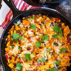 a skillet filled with mexican food and garnished with fresh cilantro