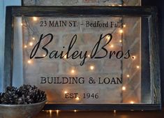 a sign that says bailey bros building and loan next to a potted pine cone