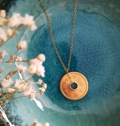 The Pendant with the Japanese 5 yen coin. Apart from being one of the coins of Japan, the 5 yen coin is considered by many to be an amulet, and is given on special occasions to attract luck. In Japan it is called "omamorisen" which means "lucky coin", maybe the name reminds you of something... because the brand name "Omamori" means "amulet" in Japanese! If you ever travel to Japan, you will see that in each temple or sanctuary, there will be a store where you can buy one of them. The pendant is Amulet Coin Necklace For Gift, Symbolic Round Coin Pendant Necklace, Gratitude Ideas, Travel To Japan, Attract Luck, Kitsune Mask, Halloween Shopping, Jewelry Necklace Pendant, Temple