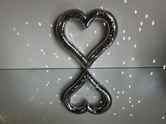 a heart shaped metal object hanging on the wall