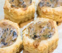 four small pastries sitting on top of a piece of parchment paper next to each other