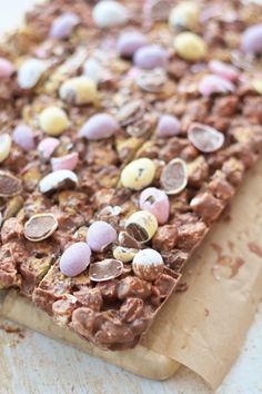 a close up of a piece of food on a cutting board with eggs and candy