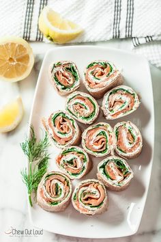 a white plate topped with rolls covered in salmon