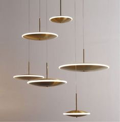 several circular lights hanging from the ceiling in a room with white walls and flooring