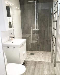 a white toilet sitting next to a walk in shower