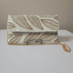 Enchant your look this season with this one-of-a-kind beaded sequin handbag! Embellished with delicate beading and sequins, it features a unique leaf shape that adds an elegant touch to your wardrobe. Make a fashion statement and upgrade your style today! Sequin Shoulder Bag For Wedding, White Beaded Party Bags, White Sequin Party Bag, Elegant White Sequined Bags, Festive White Embellished Clutch, White Embellished Clutch Bag, White Embellished Bags For Festive Occasions, White Embellished Bag For Festive Occasions, White Embellished Festive Bags