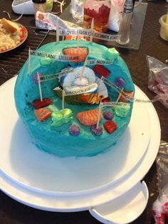 there is a blue cake on the table with many candies and candy sticks sticking out of it