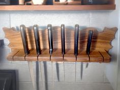 several knives are hanging on a wooden rack