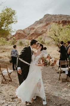 a newly married couple kissing in the desert