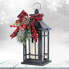 a lantern with a christmas decoration on it and snowflakes in the back ground