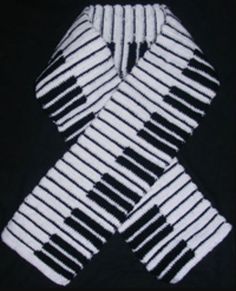 the black and white scarf is folded up to show it's diagonal stripes pattern