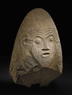 a rock with a face carved into it's side, on a black background