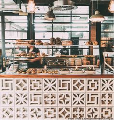 a bakery counter with lots of pastries on it and lights hanging from the ceiling