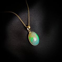 This stunning Pendant is set in 14k Solid Yellow Gold with Natural Ethiopion White Opal with utmost precision. It is a unique gemstone Pendant for nearly every occasion and is completely hassle-free jewelry. ITEM DETAILS: * GEM: White Opal * GEM SIZE: 12.5X15mm * GEM SHAPE: Oval * Gem weight: 4.03 carats * Gold Purity: 14KT  * Gold Weight: 0.55 gram * Total Weight of the Pendant: 1.34 gram The Gold purity is guaranteed and it comes with authentic 14KT gold hallmark. Since my items are handmade, Yellow Gold Ethiopian Opal Cabochon Jewelry, 14k Yellow Gold Gemstones For Gift, Hallmarked Yellow Gold Gemstones For Gift, High Luster Oval Gemstones For Gifts, Oval Fine Jewelry With High Luster, Oval 14k Gold Jewelry With High Luster, Yellow Gold Ethiopian Opal Round Necklace, Oval 14k Gold High Luster Jewelry, Oval Yellow Gold Jewelry With High Luster