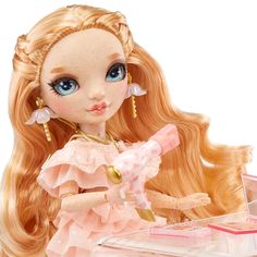 a doll with long blonde hair and blue eyes is sitting at a desk in front of a mirror