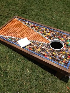 a coffee table made out of bottle caps on the grass with a hole in it