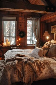 a bed in a room with two windows and candles on the wall next to it