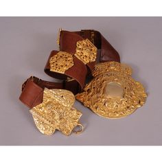 This supple brown leather belt is embellished with a large gold toned buckle and seven decorative slides in two different styles. The belt is stamped  Made in Italy by Roberta Di Camerino Expressly for Saks Fifth Ave. It is in excellent condition and appears unworn. Measurements; Belt  Length 32" Width 1 3/8" Buckle Height 5"  Please see the measurements noted above in the description for best approximate dimensions Designer Brown Belt Buckles With Gold Buckle, Designer Brown Belt Buckles, Designer Brown Belt Buckles With Removable Belt, Designer Brown Belt With Gold Buckle, Elegant Brown Belt Buckles With Brass Hardware, Luxury Belts With Brass Hardware, Luxury Brown Belts With Brass Hardware, Luxury Brown Belt With Brass Hardware, Formal Brown Belt Buckles With Brass Hardware