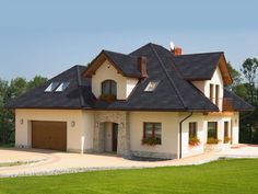 a large house with a green roof and two garages