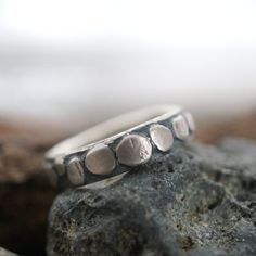 This is a unique, textured sterling silver ring with an organic look and natural feel.  From the forge, created by fire and force. Sterling Silver ring with fused-on, rough fine Silver plates, a narrow band makes a bold statement.  Measurements: Size: 7.75; Width 5mm; The ring is 2.7mm thick. Material: Fine Silver and Sterling Silver, Hard Silver solder. Liver of Sulphur Packaging: Your item will come wrapped in a lovely, handmade Kraft paper gift box. Process: The rough band was melted, rolled Sterling Silver Jewelry With Unique Texture, Silver Sterling Jewelry With Unique Texture, Unique Hammered Stackable Rings For Promise, Hand Forged Sterling Silver Rings In Nature-inspired Style, Hand Forged Sterling Silver Nature-inspired Rings, Hand Cast Sterling Silver Nature-inspired Rings, Nature-inspired Hand Forged Sterling Silver Rings, Nature-inspired Hand Cast Sterling Silver Rings, Silver Plates