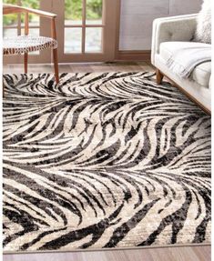 a zebra print rug in a living room next to a couch and chair with a window