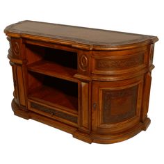 a wooden entertainment center with carvings on the front and side panels, along with shelves