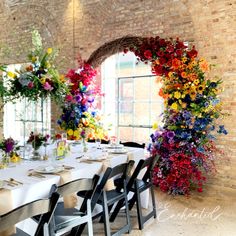 the table is set with many flowers and place settings for people to sit at it