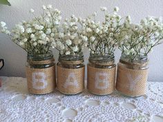 four mason jars with white flowers in them