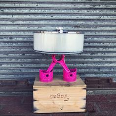 a pink lamp sitting on top of a wooden box