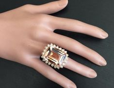 a woman's hand with a ring on top of it and an orange stone in the middle