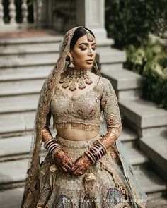 a woman wearing a bridal outfit standing in front of stairs