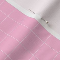 a pink and white checkered table cloth with pins sticking out of the center,