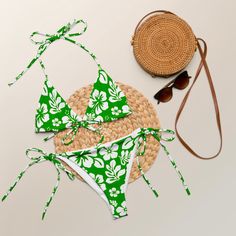 Indulge in the luxurious and exclusive style of our White Hawaiian Flowers on Fresh Green String Bikini. This beautiful string bikini set is not only comfortable, but it also offers double-layering and UPF 50+ protection. Customize the straps to your liking and get ready to turn heads at the beach! Made from soft recycled polyester, this bikini is both stylish and sustainable. • Soft and stretchy material with UPF 50+ • Sizes up to 6XL • Bikini top comes with removable padding for comfort • Mult Green Tropical Tie-side Swimwear, Tropical Green Tie-side Swimwear, Tropical Green Tie-side Swimwear Bottom, Tropical Strappy Swimwear For Beach Season, Tropical Strappy Swimwear For The Beach, Tropical Strappy Swimwear For Poolside, Adjustable Swimwear For Vacation, Tropical Strappy Swimwear For Sunbathing, Beachy String Swimwear For Beach