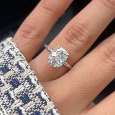 a close up of a person's hand with a diamond ring on their finger